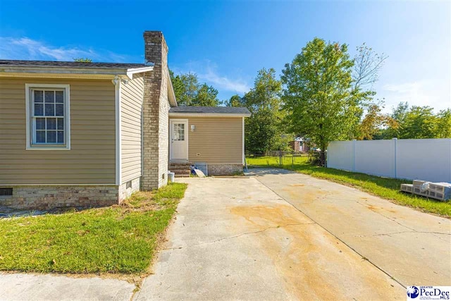 view of property exterior featuring a patio area and a lawn