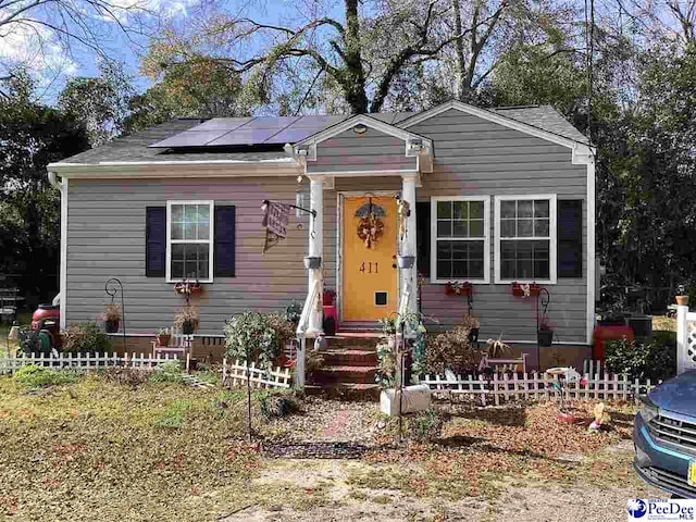 view of front facade with solar panels and fence