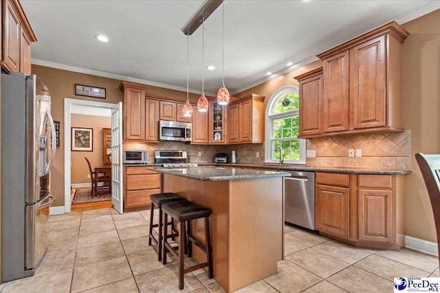 3250 Hampton Pointe Dr, Florence, SC 29501 - kitchen featuring stainless steel appliances, ornamental molding, brown cabinetry, a kitchen island, and backsplash