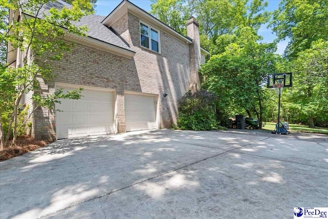 3250 Hampton Pointe Dr, Florence, SC 29501 - view of side of property featuring concrete driveway, brick siding, and a chimney
