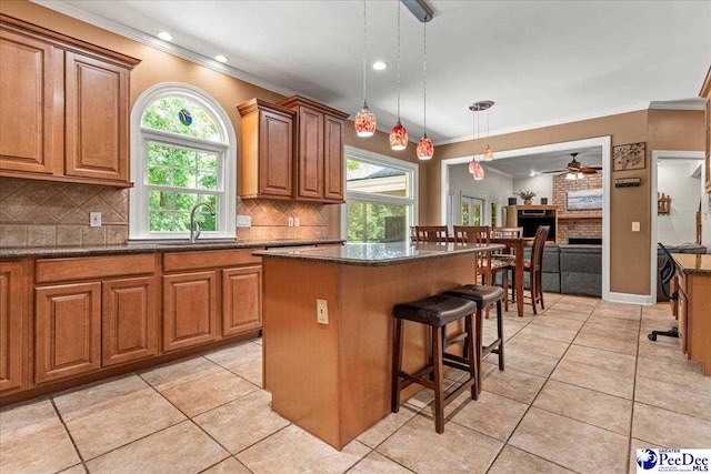 3250 Hampton Pointe Dr, Florence, SC 29501 - kitchen with ornamental molding, a ceiling fan, a kitchen island, tasteful backsplash, and a sink