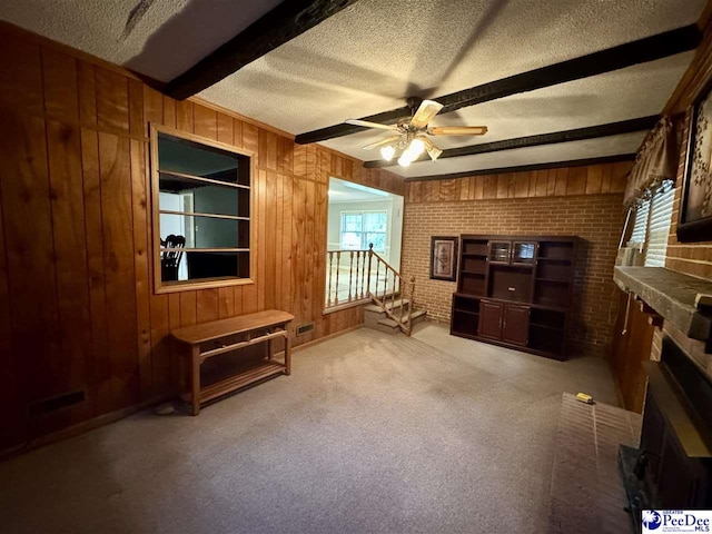 109 Tec Rd, Cheraw, SC 29520 - living room with a fireplace, a textured ceiling, wood walls, beam ceiling, and ceiling fan