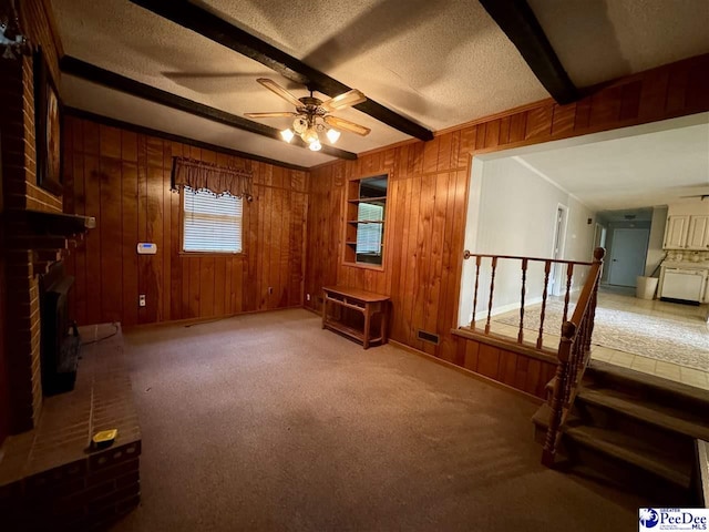 109 Tec Rd, Cheraw, SC 29520 - unfurnished living room with beam ceiling, a ceiling fan, a brick fireplace, a textured ceiling, and wooden walls