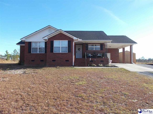 view of front of home with a front yard, a carport, and covered porch