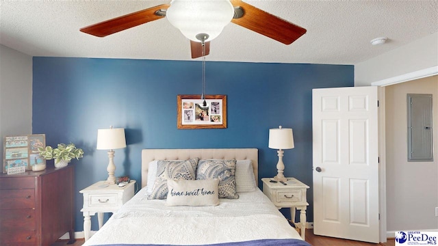 bedroom featuring ceiling fan, electric panel, and a textured ceiling