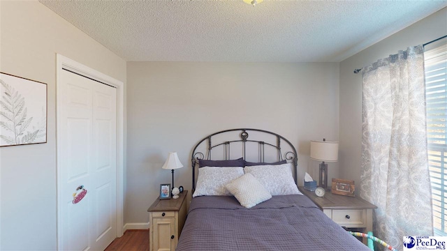 bedroom with hardwood / wood-style flooring and a textured ceiling