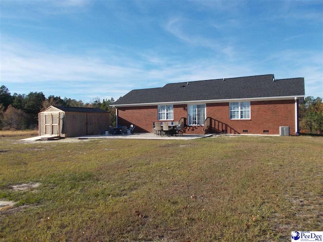 rear view of house with a yard, a patio, central air condition unit, and a storage unit