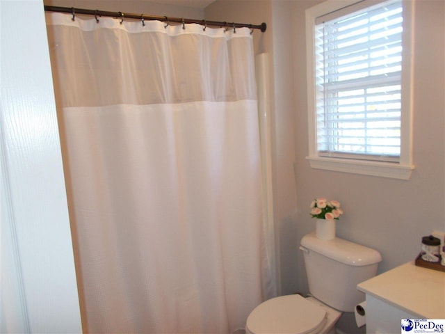 bathroom featuring a shower with curtain, vanity, and toilet