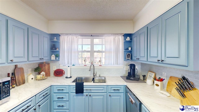 kitchen with blue cabinets, ornamental molding, sink, and a textured ceiling