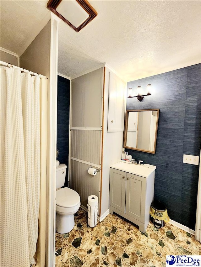 bathroom with a shower with curtain, vanity, toilet, and a textured ceiling