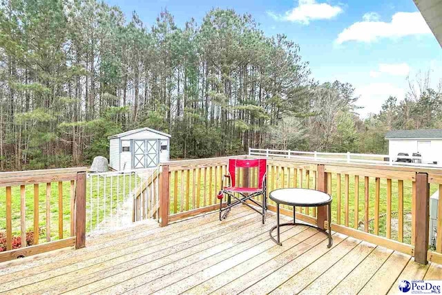 wooden terrace featuring a shed and a lawn