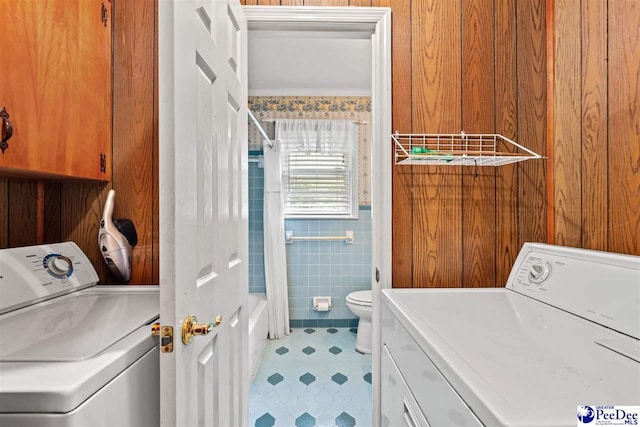 laundry room featuring separate washer and dryer, crown molding, and tile walls