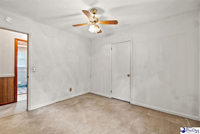 carpeted empty room featuring ceiling fan and a textured ceiling