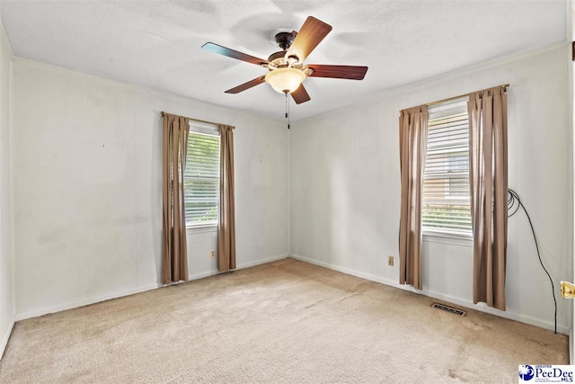 carpeted spare room featuring a textured ceiling and ceiling fan