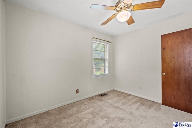 spare room with light colored carpet and ceiling fan