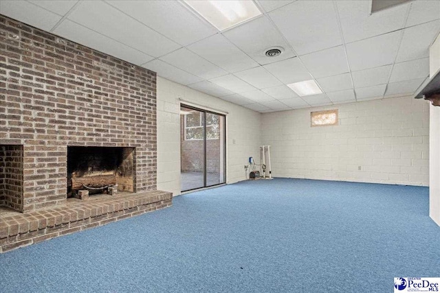 basement with carpet, visible vents, a fireplace, and a drop ceiling