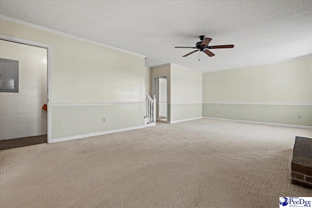 unfurnished living room with a textured ceiling, carpet floors, electric panel, and crown molding