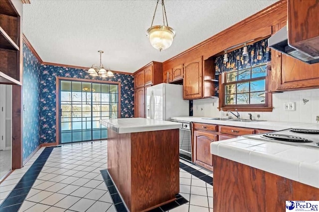 kitchen with wallpapered walls, a textured ceiling, and a sink