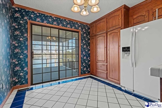 kitchen featuring wallpapered walls, white fridge with ice dispenser, and a textured ceiling