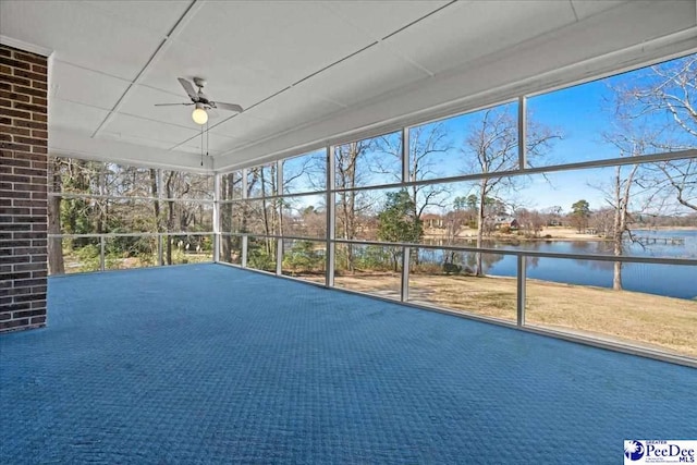 unfurnished sunroom with a drop ceiling, a water view, and a ceiling fan