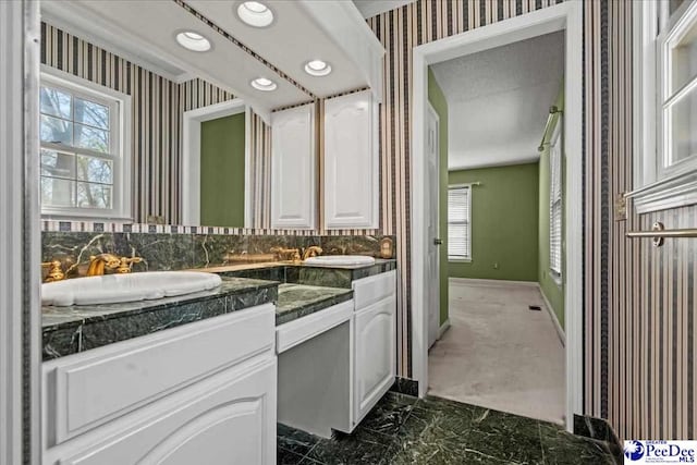 bathroom featuring marble finish floor, plenty of natural light, and wallpapered walls