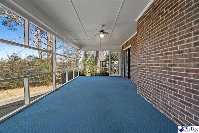 unfurnished sunroom with ceiling fan