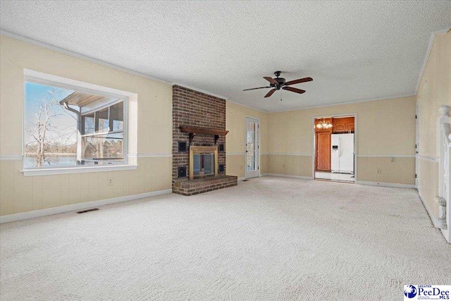 unfurnished living room featuring visible vents, ceiling fan, a textured ceiling, carpet floors, and a brick fireplace