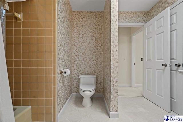 bathroom with baseboards, wallpapered walls, toilet, and tile patterned floors