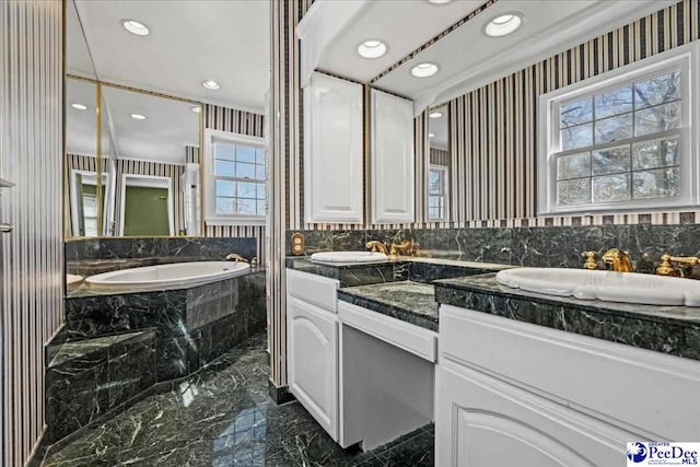 full bath with recessed lighting, a sink, marble finish floor, a bath, and double vanity