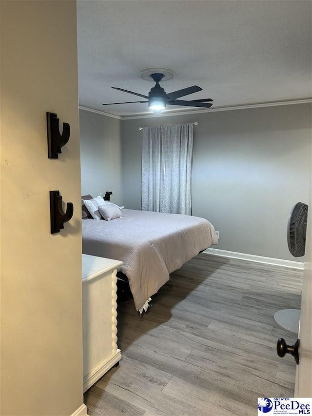 bedroom with crown molding, light hardwood / wood-style flooring, and ceiling fan