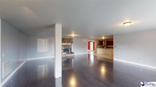 unfurnished living room with a fireplace and dark hardwood / wood-style floors