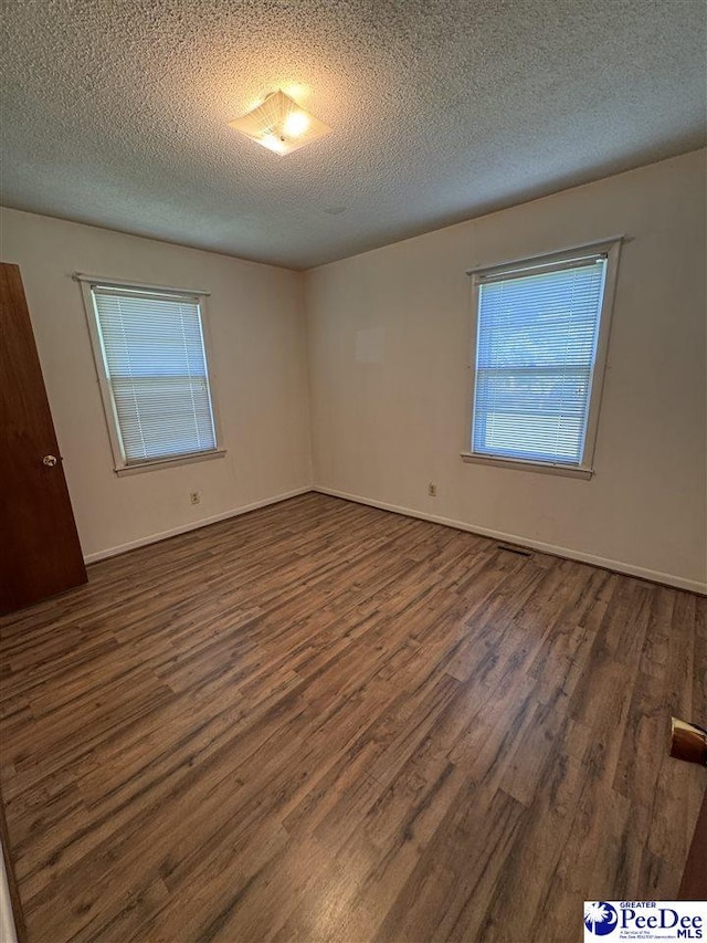 1816 Southern Acres Loop, Dillon, SC 29536 - empty room featuring dark wood-type flooring and a textured ceiling