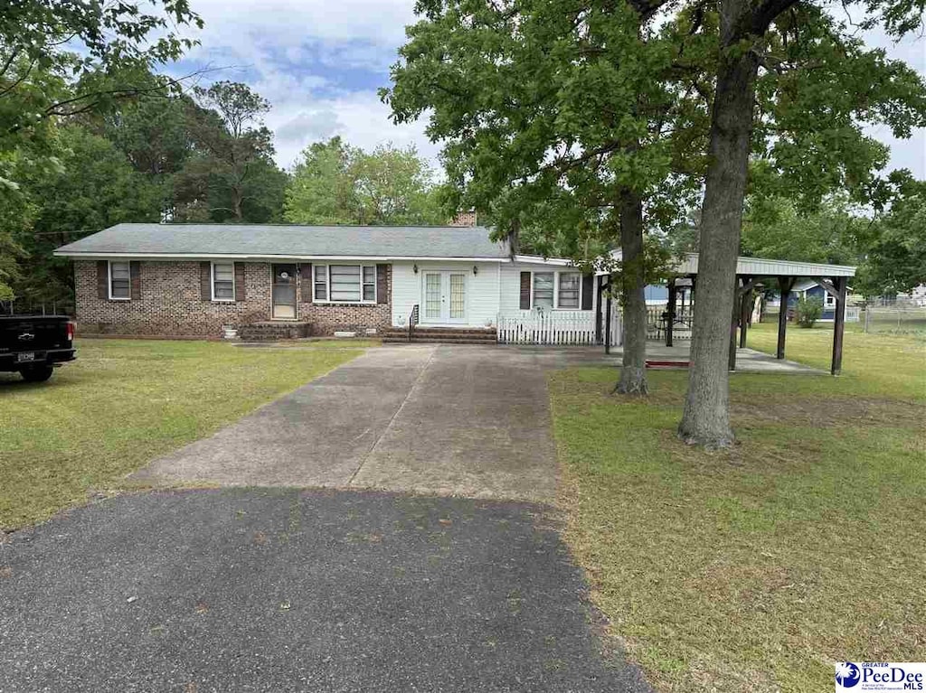 1816 Southern Acres Loop, Dillon, SC 29536 - ranch-style house featuring asphalt driveway, a front yard, french doors, and brick siding