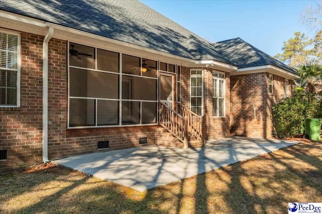 rear view of house with ceiling fan, a yard, a sunroom, and a patio