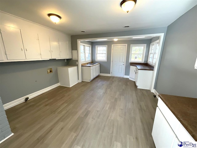 laundry room with cabinet space, wood finished floors, baseboards, and washer hookup