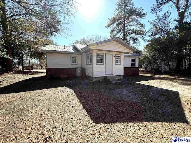 back of house with metal roof and entry steps