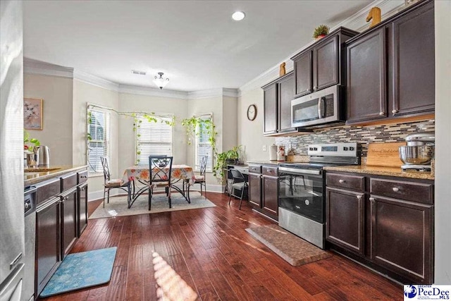 kitchen with crown molding, appliances with stainless steel finishes, dark hardwood / wood-style floors, dark brown cabinetry, and tasteful backsplash