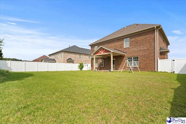 1635 Lake Wateree Dr, Florence, SC 29501 - rear view of property featuring a lawn, a fenced backyard, and brick siding