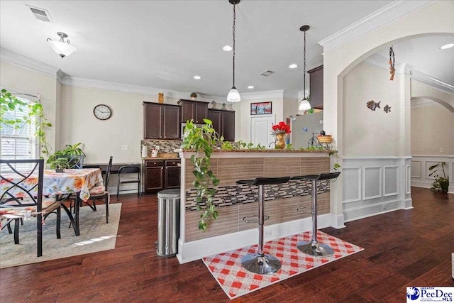 kitchen with dark brown cabinetry, hanging light fixtures, stainless steel fridge, and dark hardwood / wood-style flooring