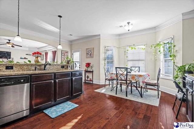 kitchen with dark hardwood / wood-style floors, dishwasher, hanging light fixtures, light stone counters, and plenty of natural light