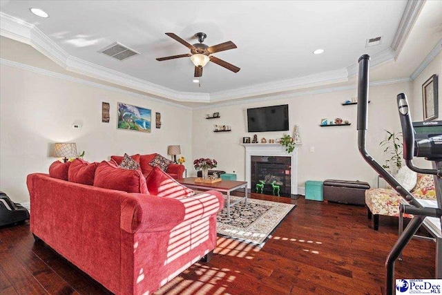 living room with crown molding, dark hardwood / wood-style floors, and ceiling fan