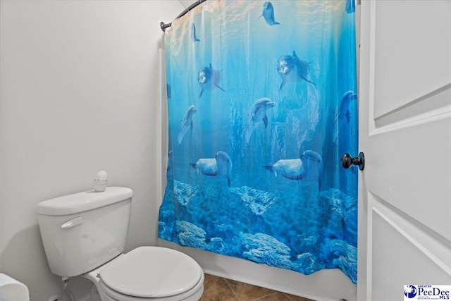 bathroom with a shower with curtain, tile patterned floors, and toilet