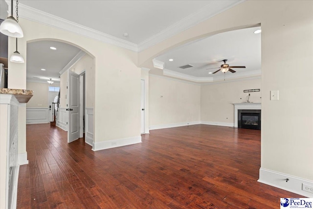 1635 Lake Wateree Dr, Florence, SC 29501 - unfurnished living room with a glass covered fireplace, ceiling fan, dark wood finished floors, ornamental molding, and visible vents