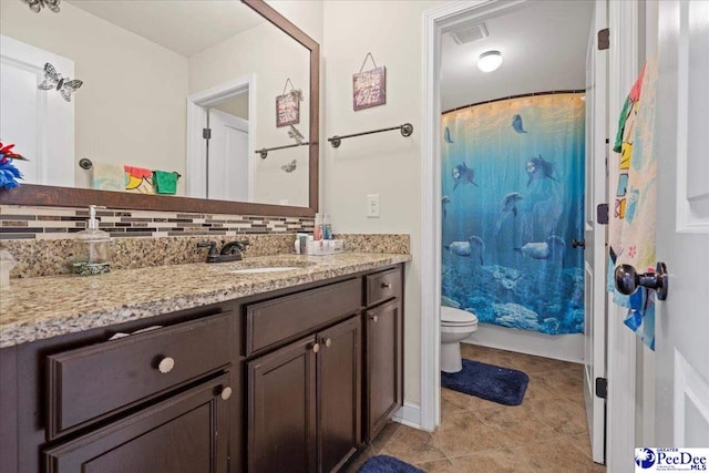 bathroom featuring vanity, toilet, tile patterned flooring, and backsplash