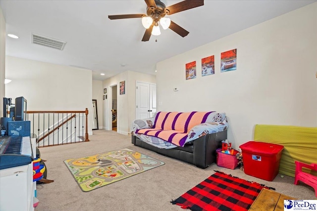 playroom featuring washer / dryer, light colored carpet, and ceiling fan