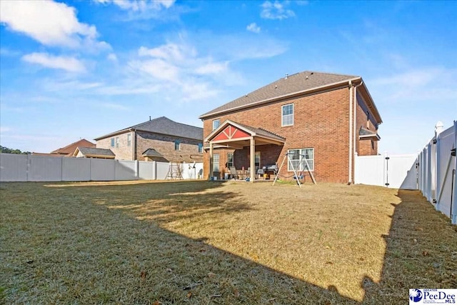 rear view of property featuring a yard