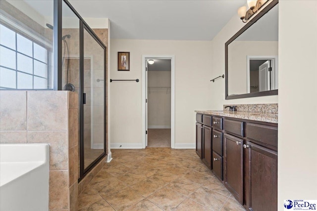 1635 Lake Wateree Dr, Florence, SC 29501 - bathroom with a tub, vanity, a spacious closet, and a stall shower