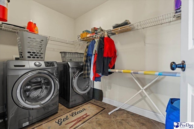 clothes washing area with separate washer and dryer and dark tile patterned flooring