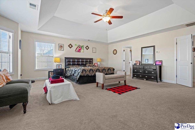 bedroom with ceiling fan, carpet flooring, and a raised ceiling