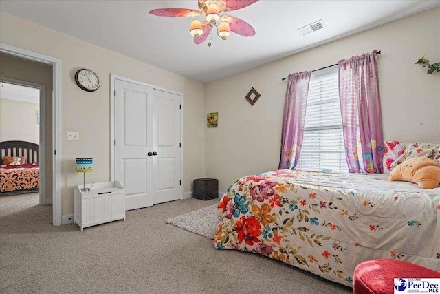 carpeted bedroom featuring ceiling fan and a closet